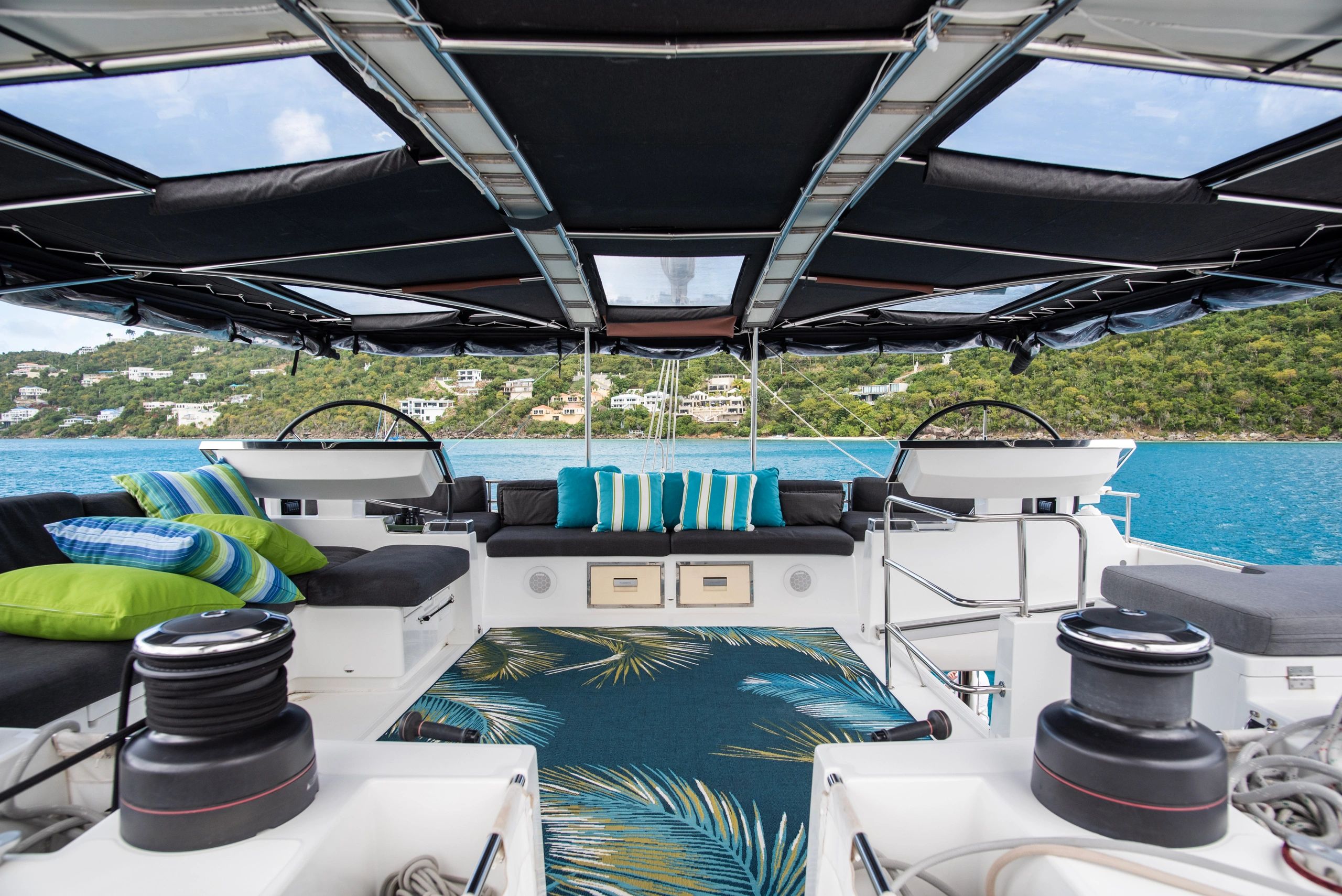 Ripple's luxurious flybridge lounge with turquoise cushions and ocean views